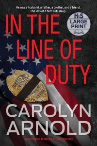 In the Line of Duty Large Print Edition by Carolyn Arnold badge with morning band covering the middle of the badge resting on a rippled US flag.