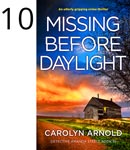 Missing Before Daylight by Carolyn Arnold, an old cabin with a light on in the window, overgrown grass on the side of a dirt road, under a fiery early morning sky.